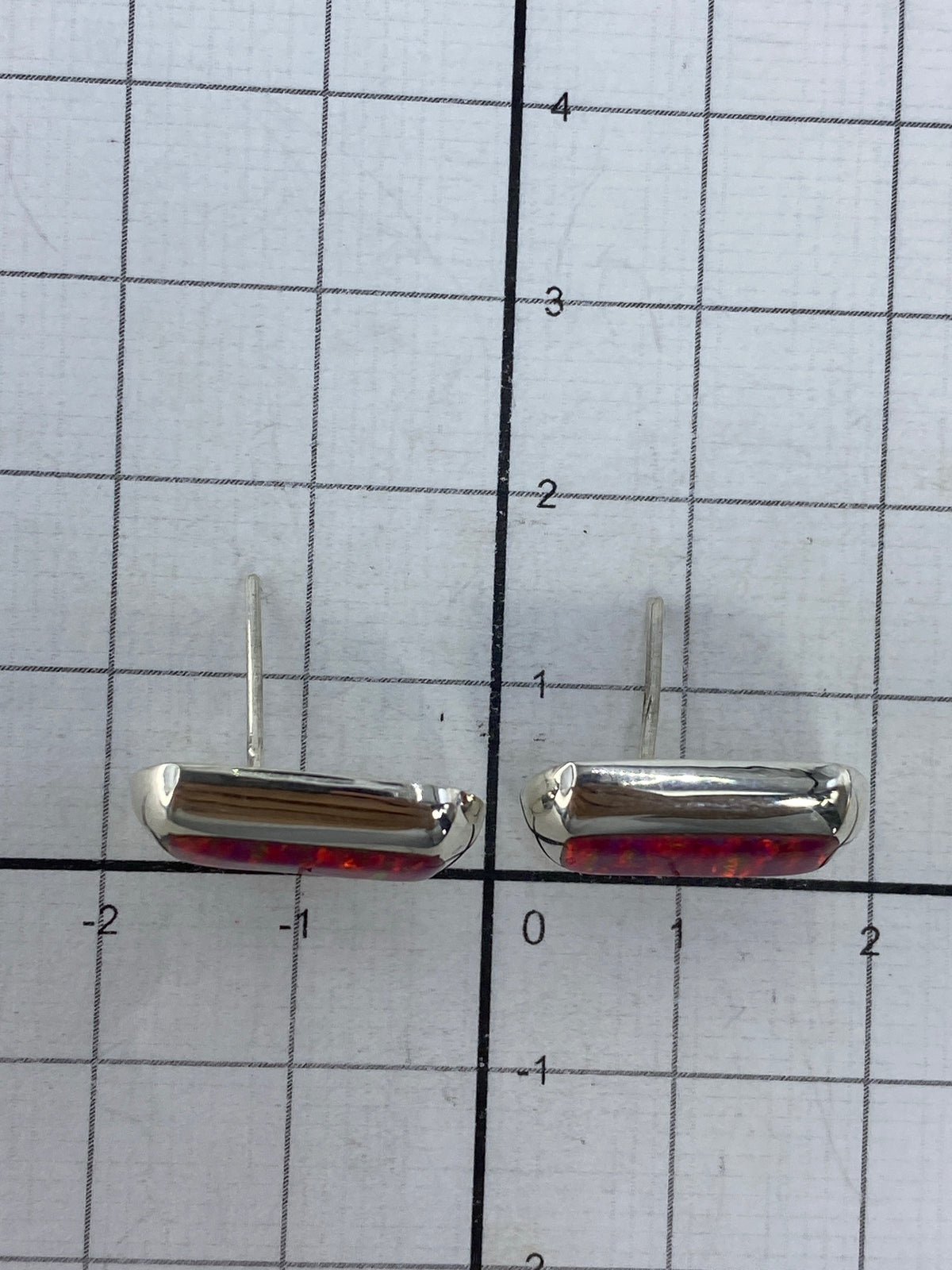 Aretes en uso, vista lateral del ópalo de fuego rosa brillando