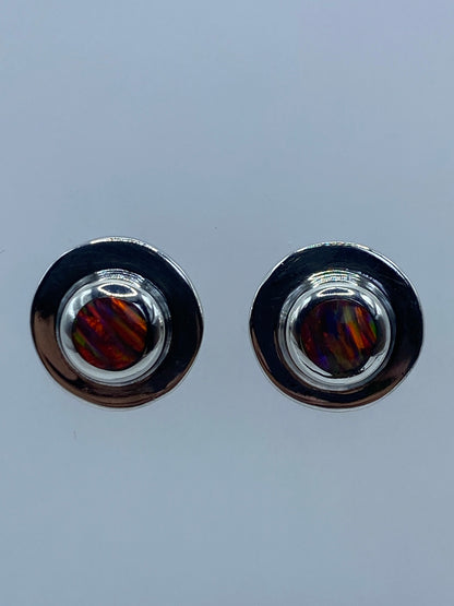 Par de aretes de plata 950 con ópalo de fuego multicolor, mostrando los tonos rojos, naranjas y azules de la piedra natural