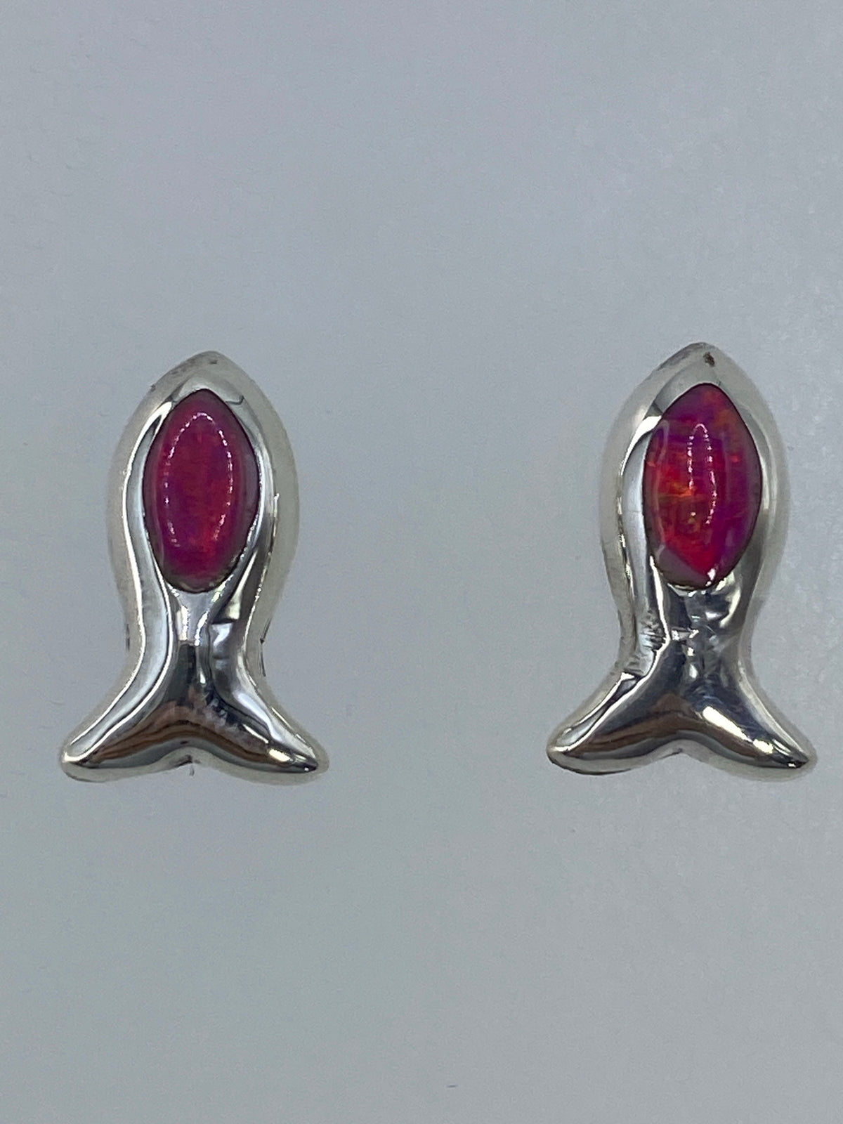 Vista frontal de los aretes minimalistas mostrando el color rosa del ópalo