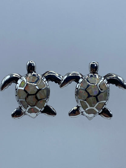 Los dos aretes juntos mostrando el tamaño y los reflejos cálidos del ópalo