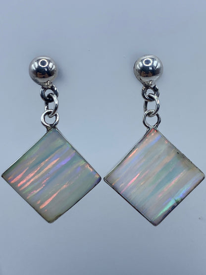 Par de aretes de plata 925 con ópalo de fuego cuadrado, mostrando los colores multicolor de la piedra