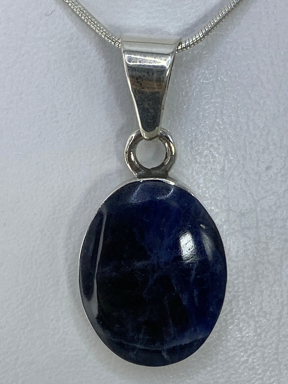 Dije de plata 950 con incrustación de piedra multicolor colgado de una cadena de plata