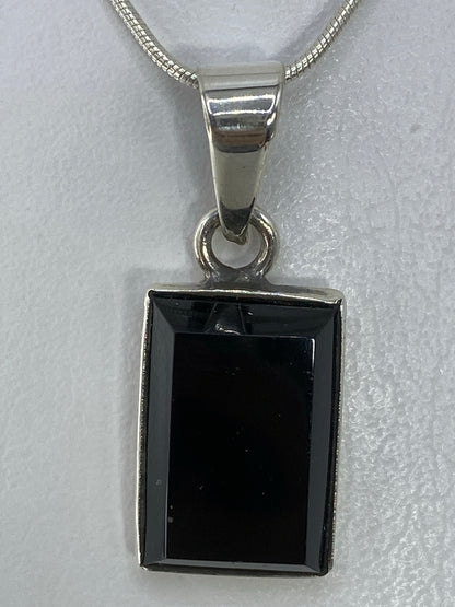 Dije rectangular de plata 950 con piedra negra engastada, sobre cadena de plata