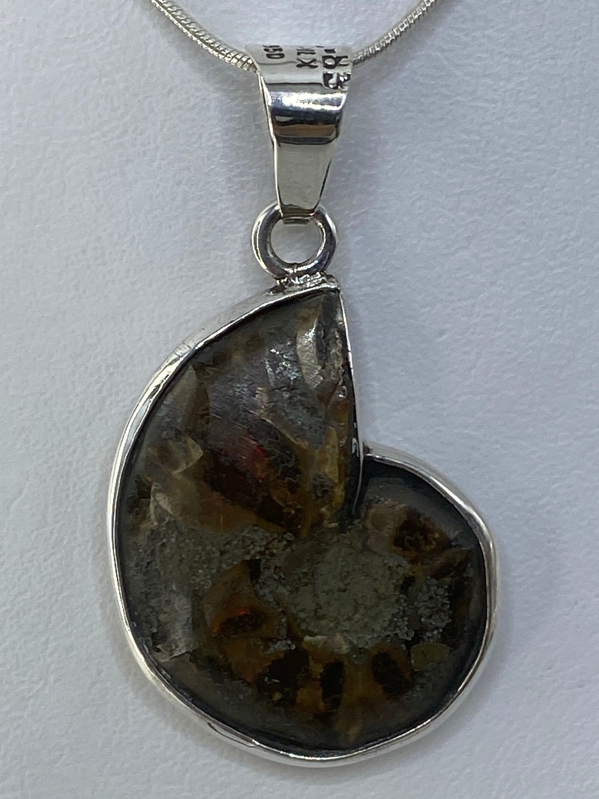 Dije de plata 950 con ópalo de fuego naranja engastado, colgando de una cadena serpentina