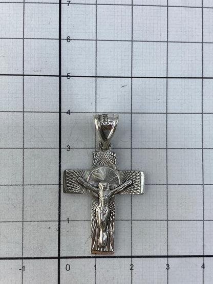 Dije sobre escala para referencia de tamaño (4 cm), con anillo de sujeción visible