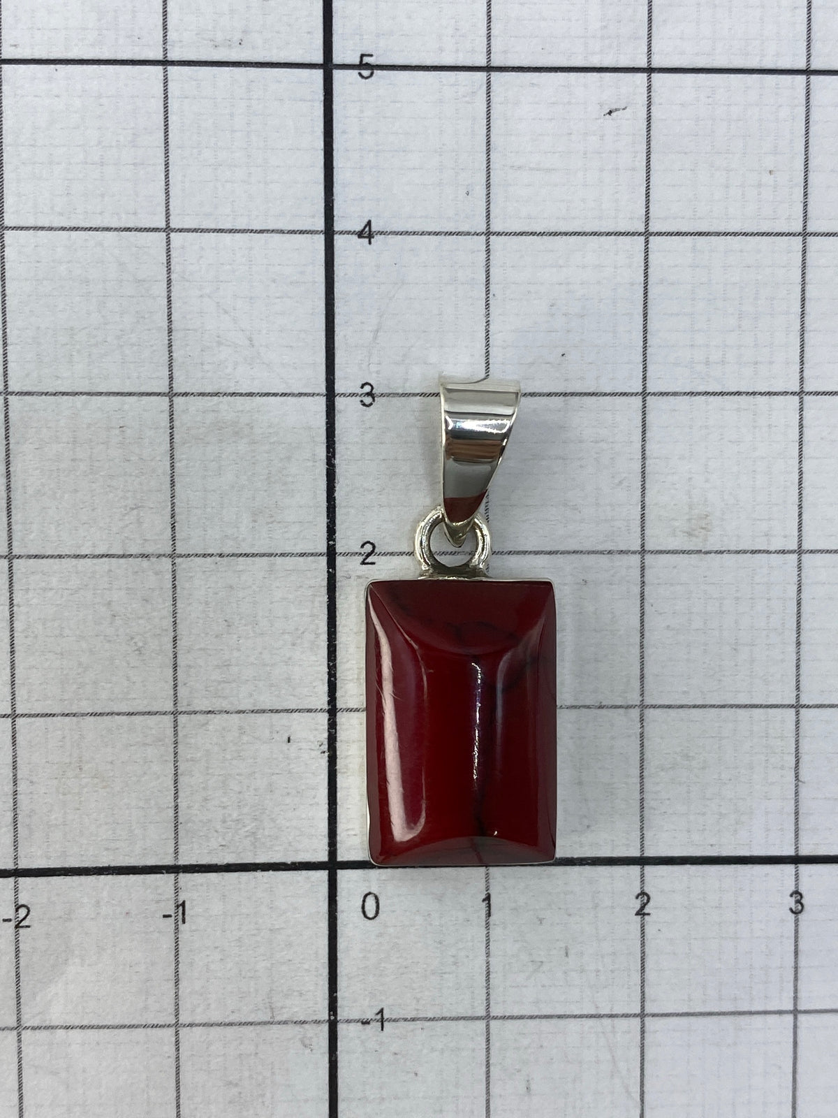 Dije sobre regla de centímetros mostrando largo de 3 cm sin cadena