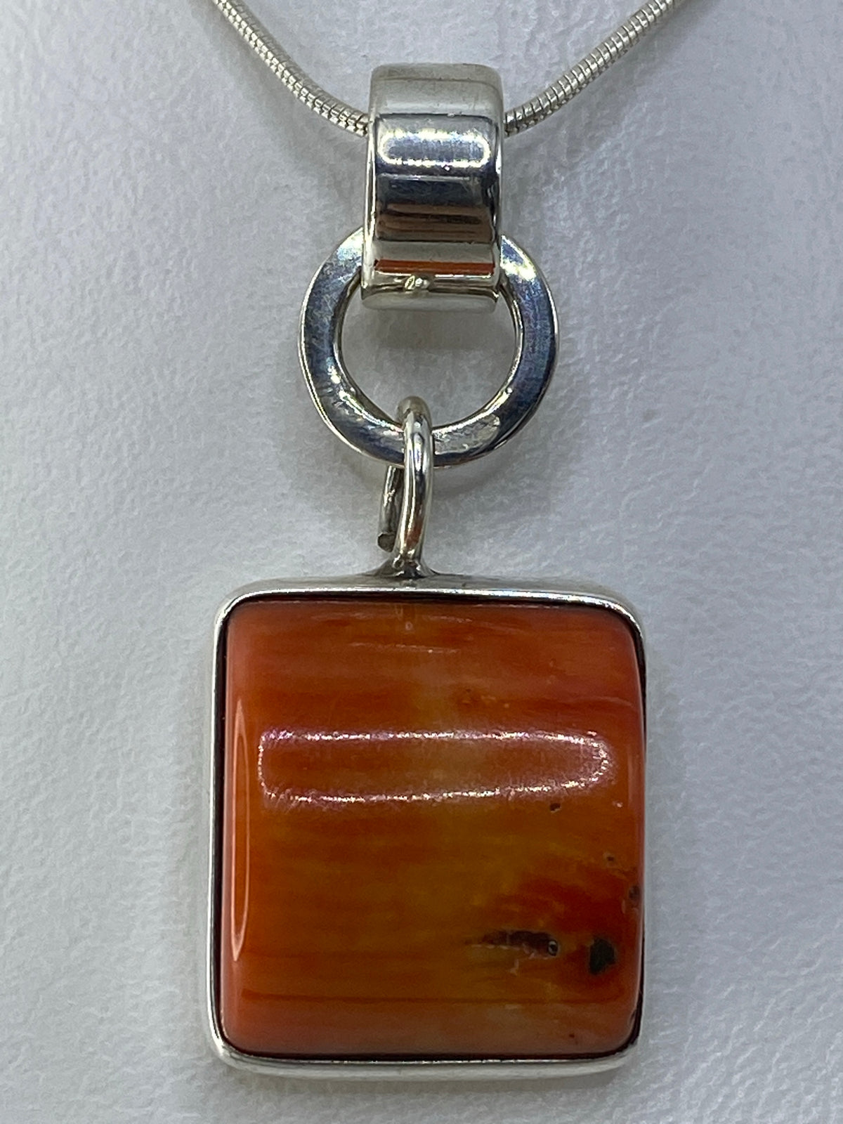 Detalle del engaste a mano de la piedra naranja en plata de Taxco