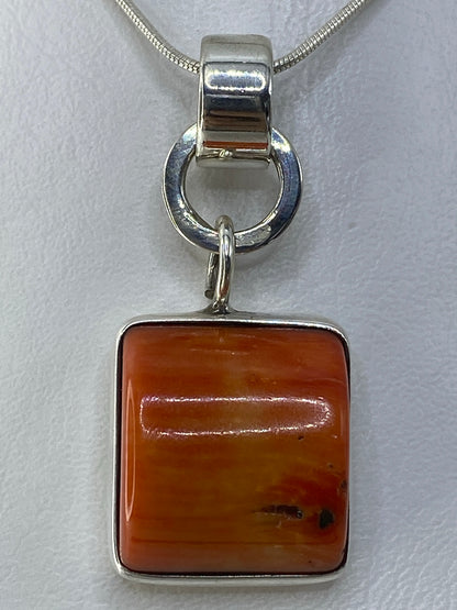 Detalle del engaste a mano de la piedra naranja en plata de Taxco