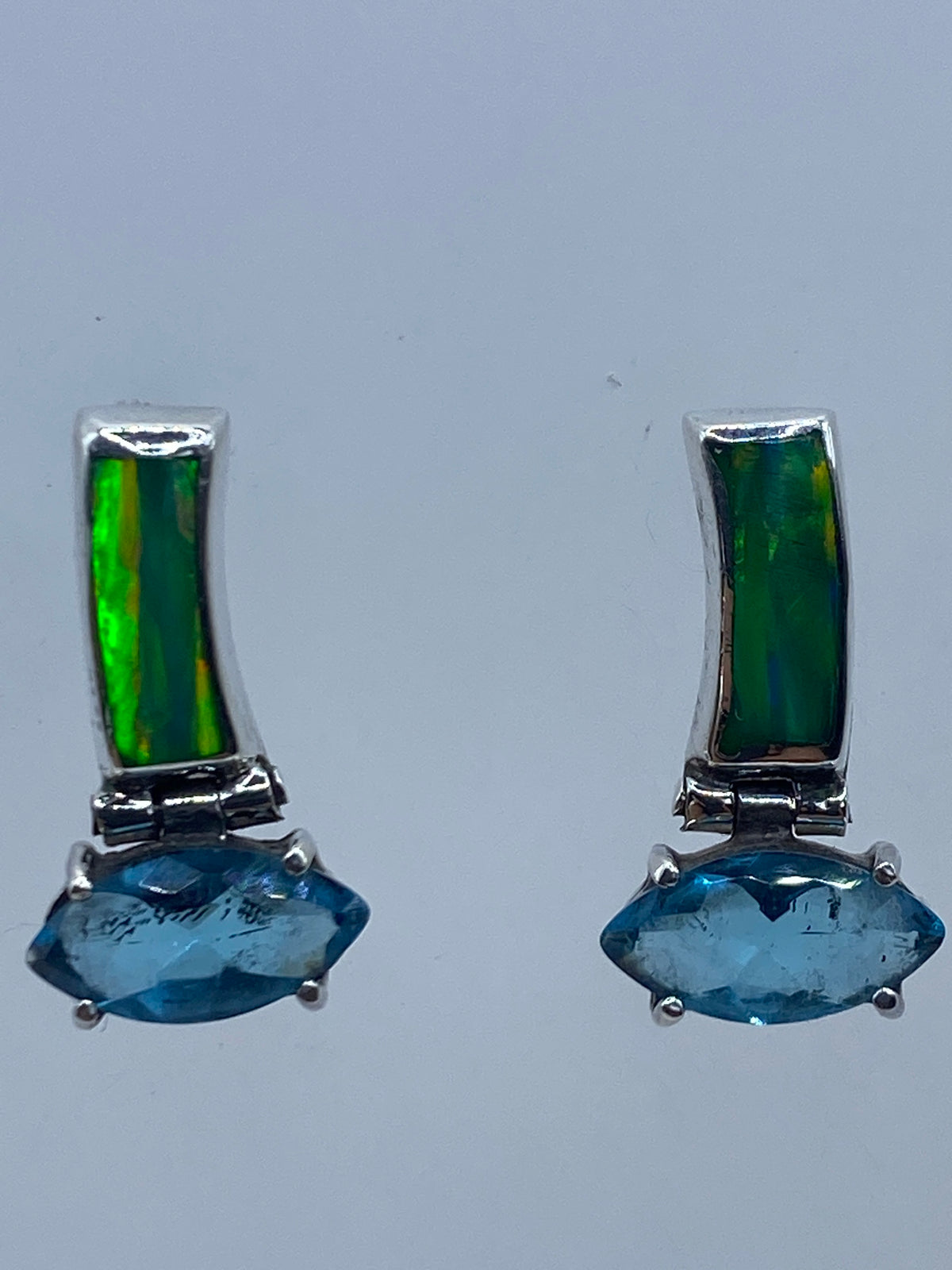 Aretes de opalo verde en la oreja, mostrando el brillo interior de la piedra