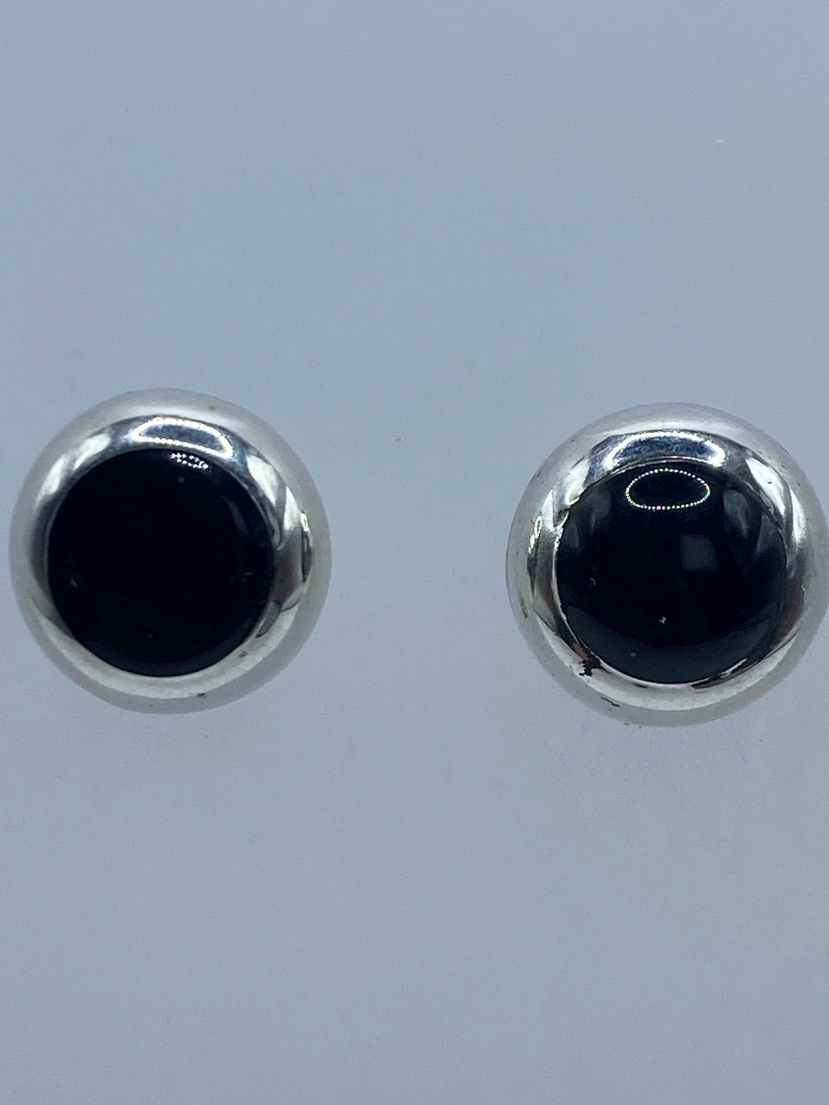 Par de aretes de plata con ónix negro pulido, vista frontal