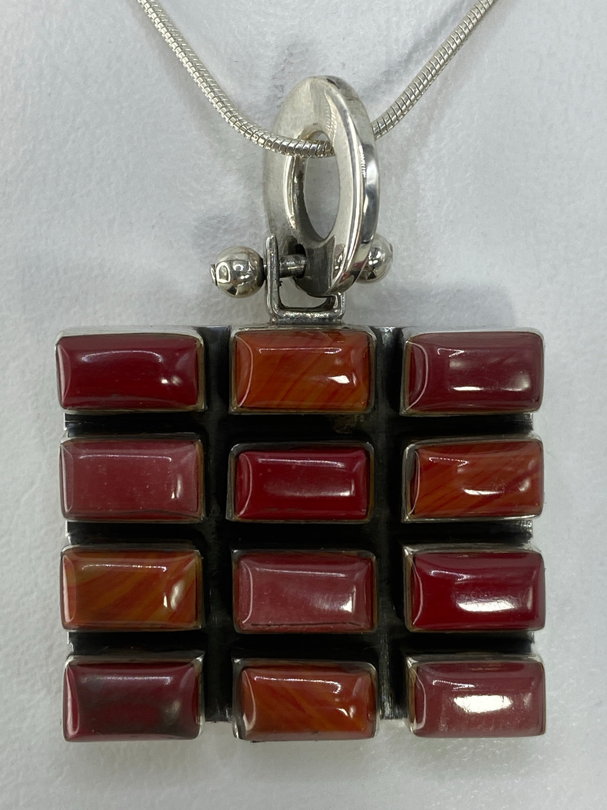 Detalle de la incrustación de piedra multicolor en el reverso del dije