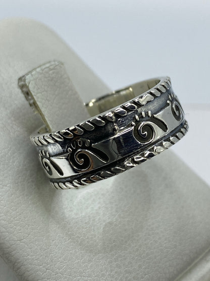 Anillo repujado unisex visto en la mano, mostrando el acabado pulido