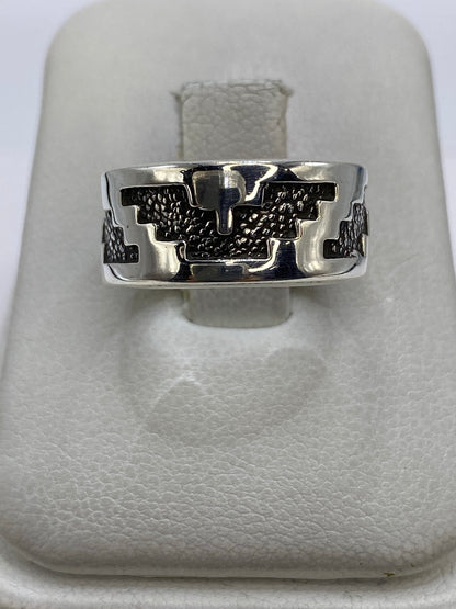 Anillo de plata repujado con motivos prehispánicos, vista frontal sobre fondo blanco