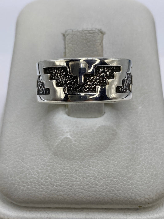 Anillo de plata repujado con motivos prehispánicos, vista frontal sobre fondo blanco