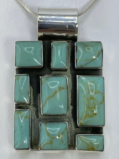 Dije de plata 925 con piedra engastada colgando de cadena de serpentín
