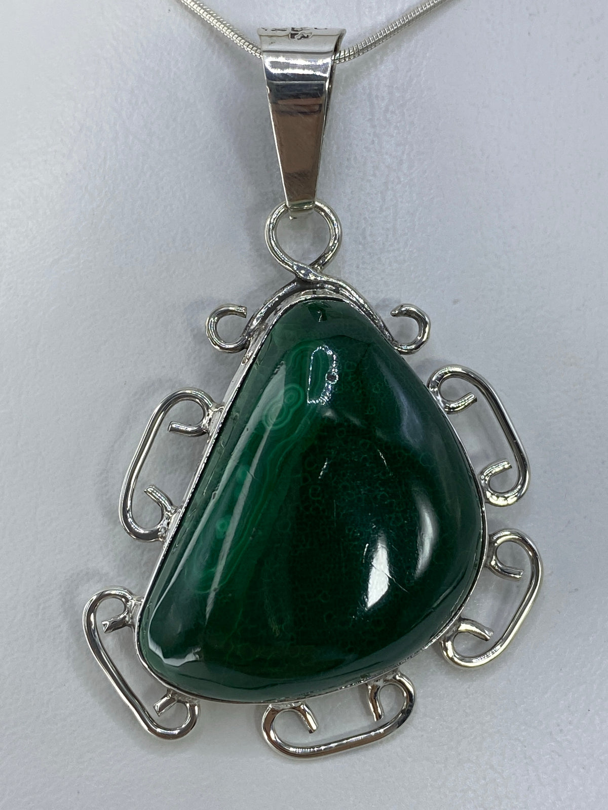 Dije de plata 950 con piedra verde pulida, vista frontal colgado de cadena de plata