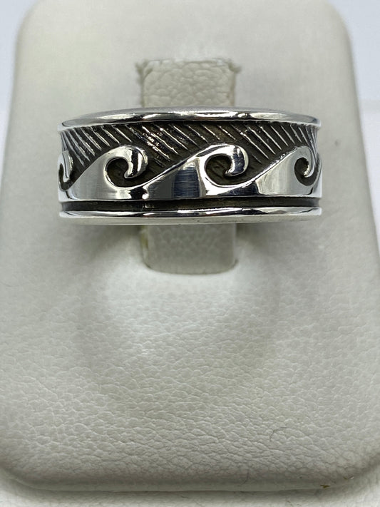 Anillo de plata repujado con ondas fluidas en la mano de una persona
