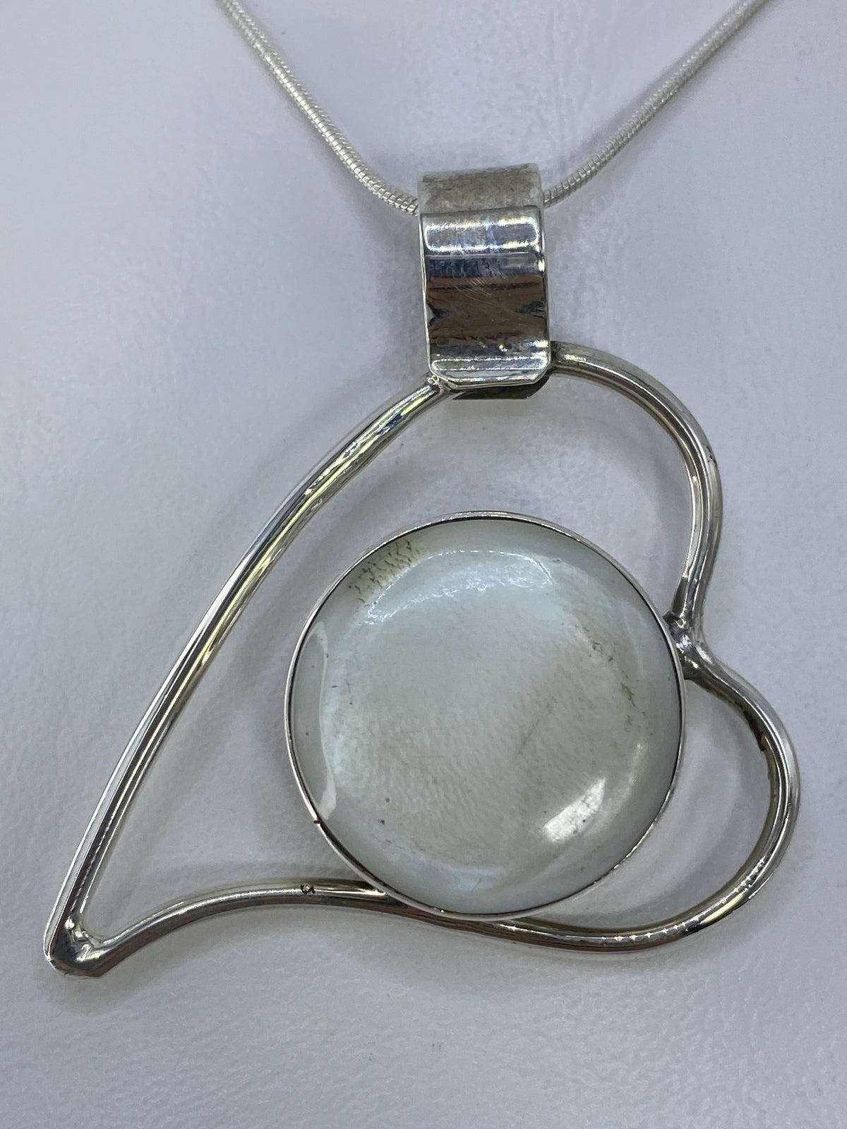 Dije corazón de plata 950 con perla blanca engastada, vista frontal