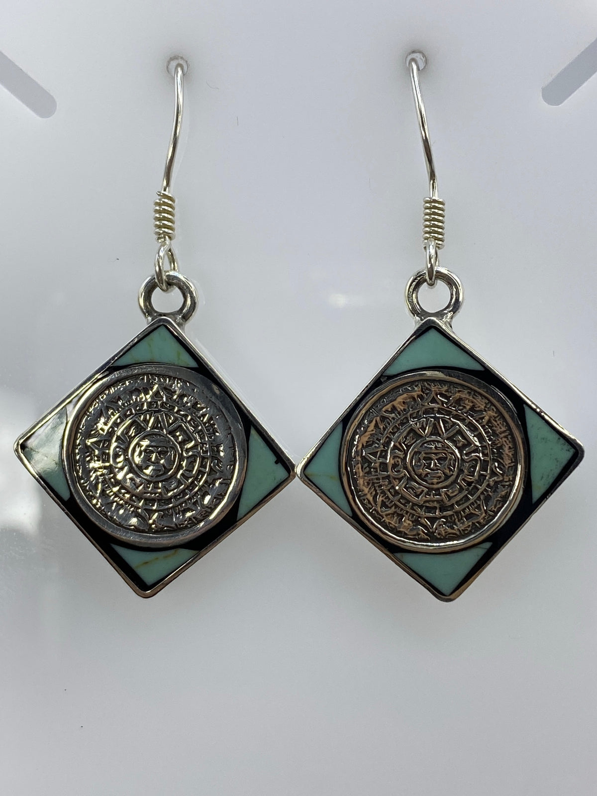Aretes en la mano mostrando tamaño de 4.9 cm y el Quinto 925 grabado