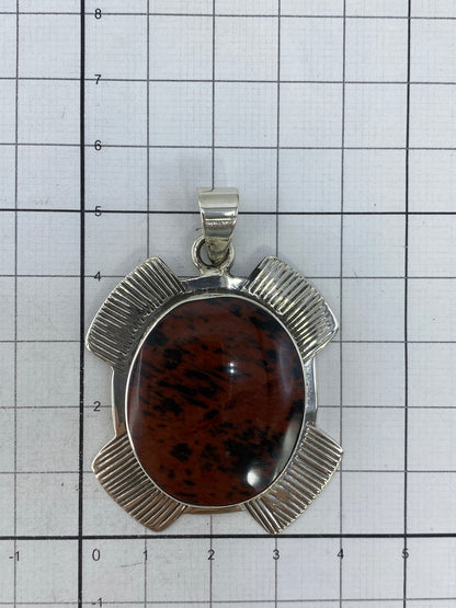 Reverso del dije floral plateado mostrando el acabado y el Quinto 950