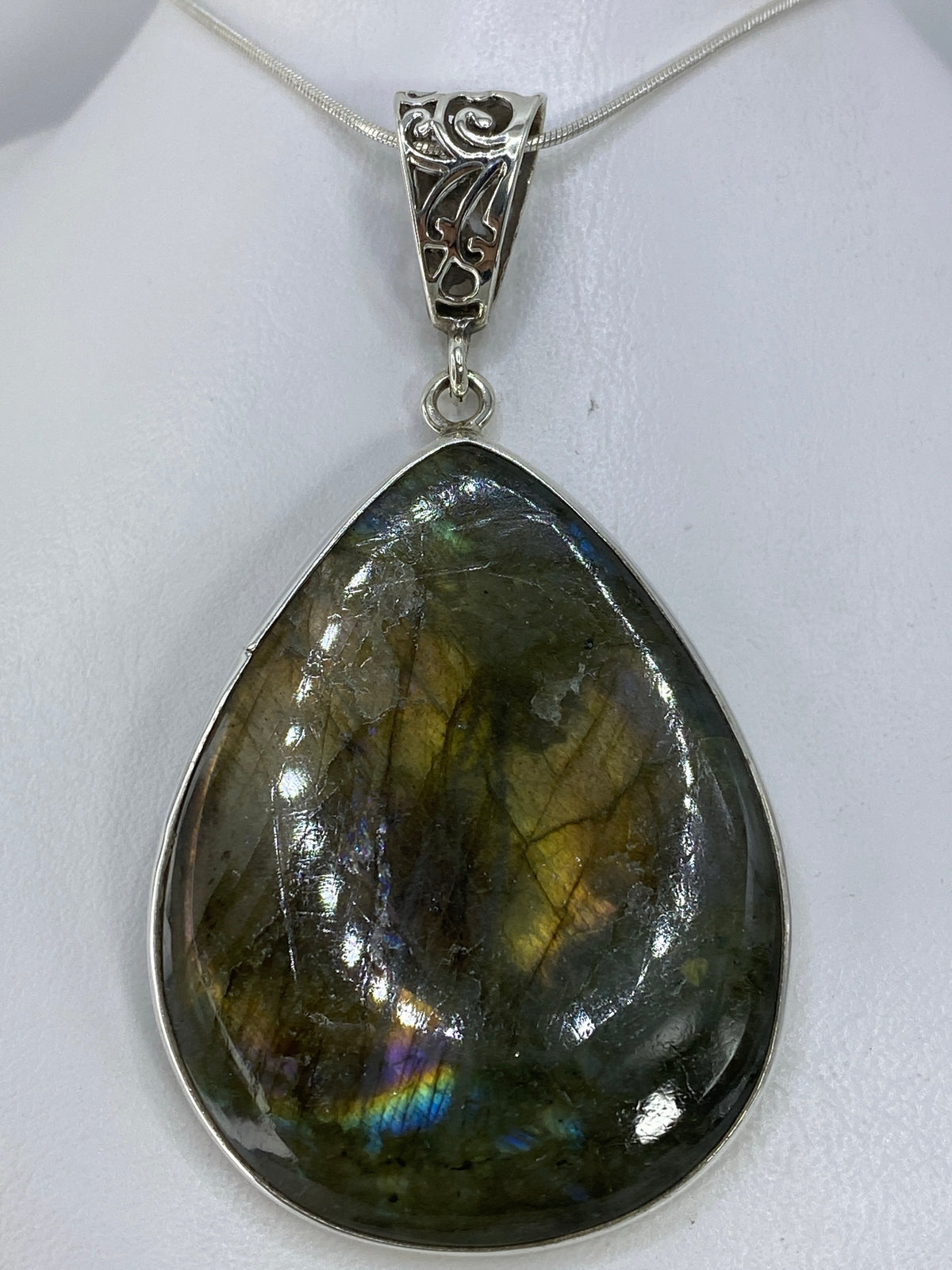 Detalle del engaste a mano de la piedra verde olivo en plata 925