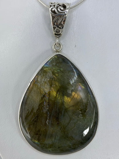 Dije con piedra natural sobre fondo blanco mostrando el Quinto 925