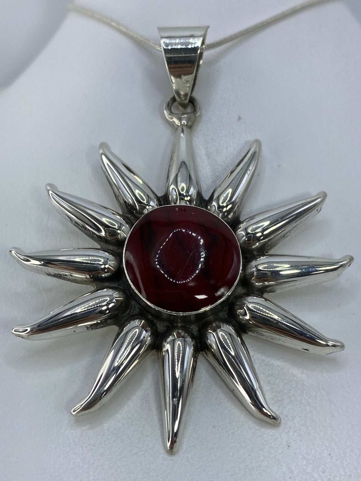 Detalle del engaste a mano de la piedra roja en el corazón del sol