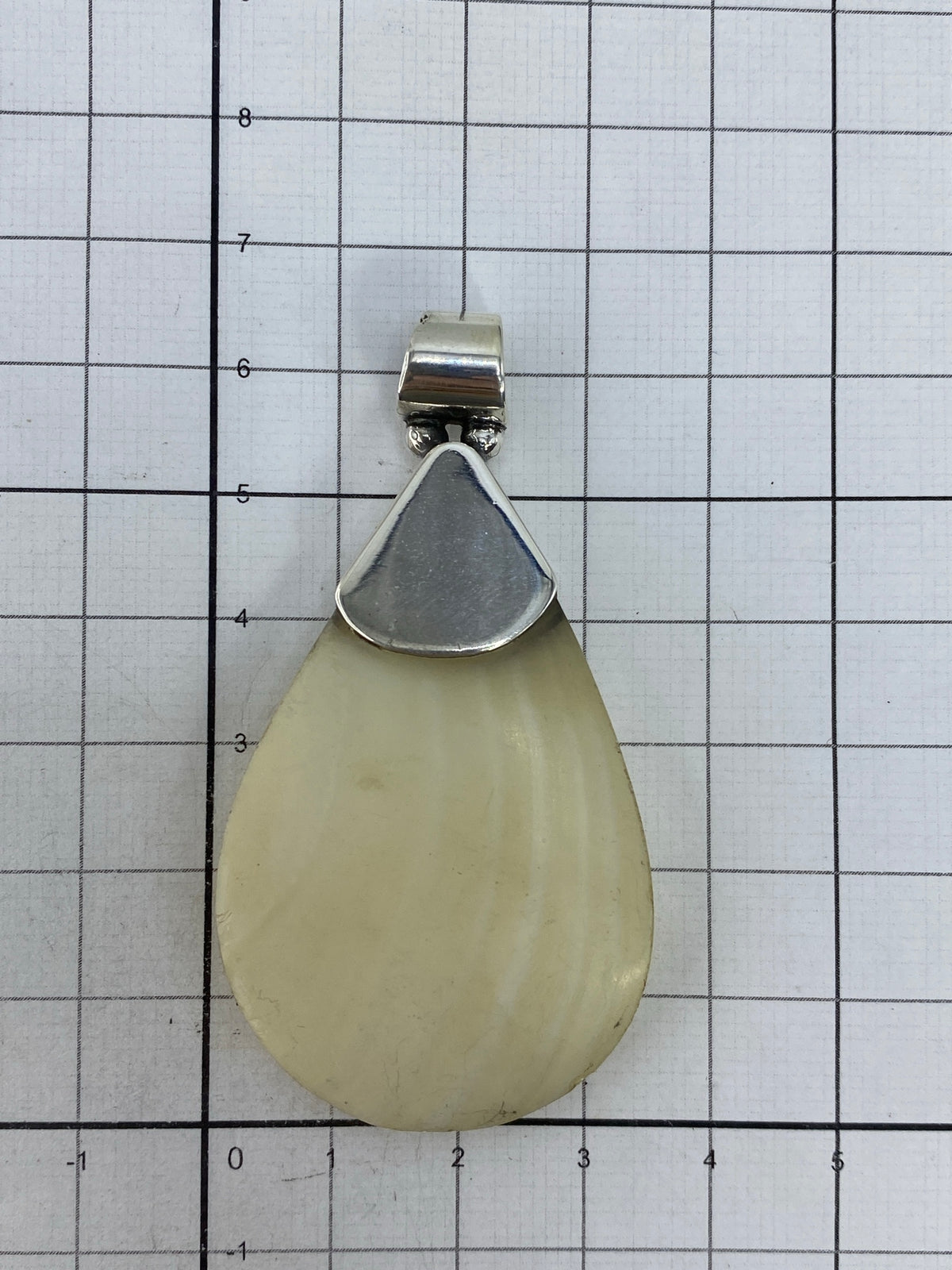 Dije de plata sobre piel, mostrando escala y presencia visual de la pieza