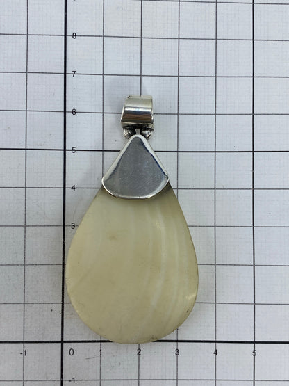 Dije de plata sobre piel, mostrando escala y presencia visual de la pieza