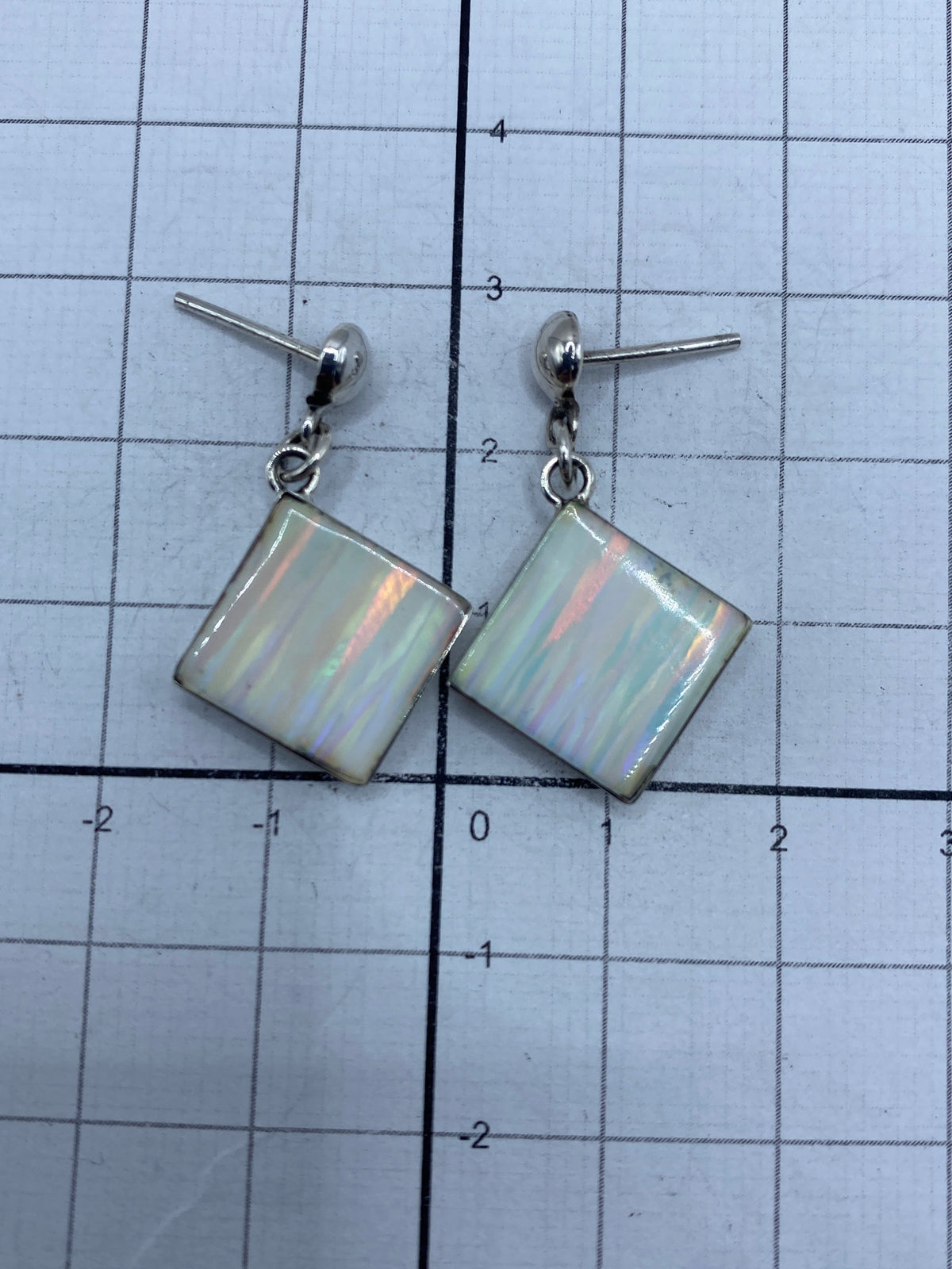 Dos aretes lado a lado mostrando el engaste a mano y el acabado pulido