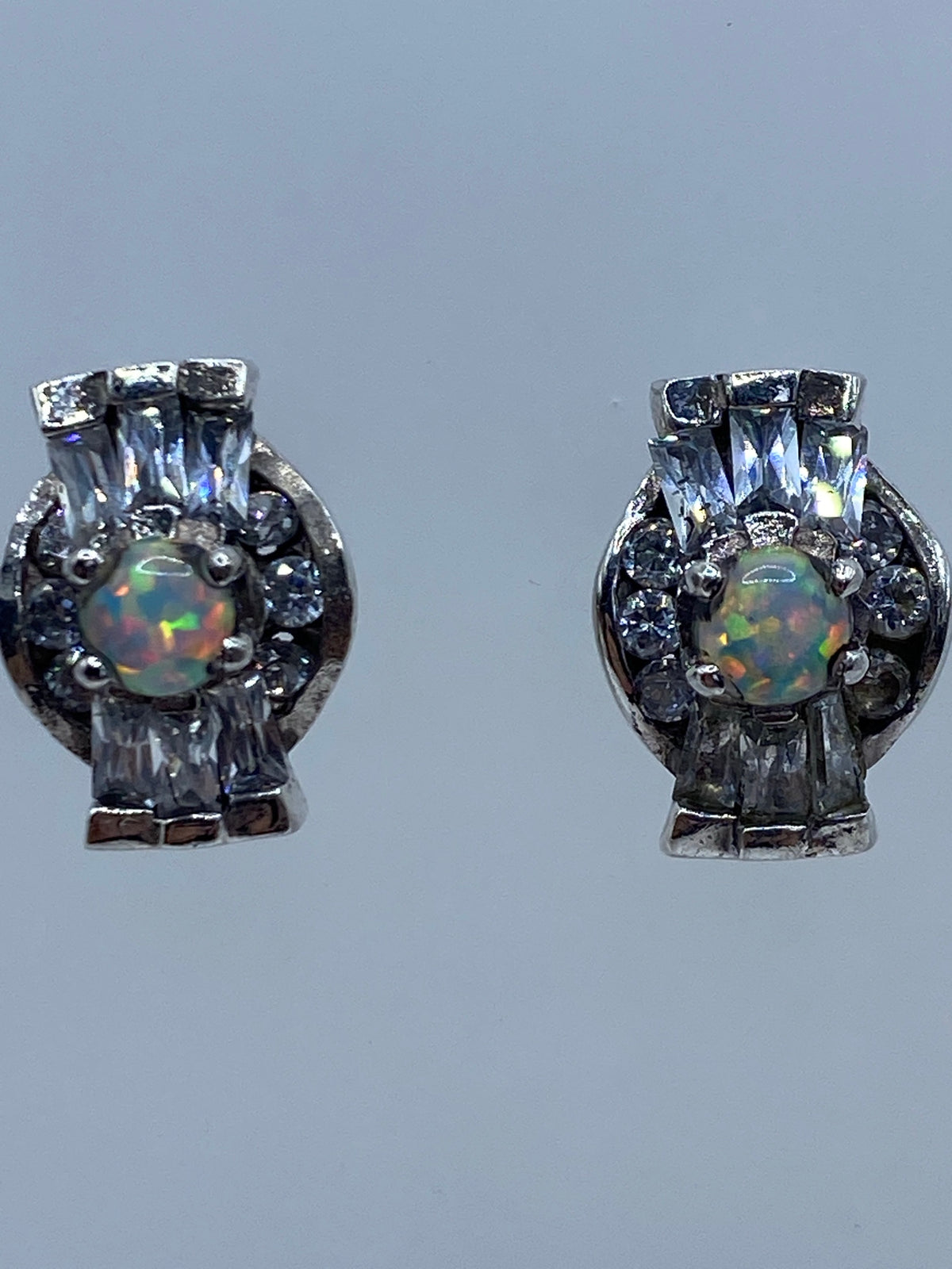 Ambos aretes vistos de lado, exhibiendo la profundidad del color del ópalo de fuego