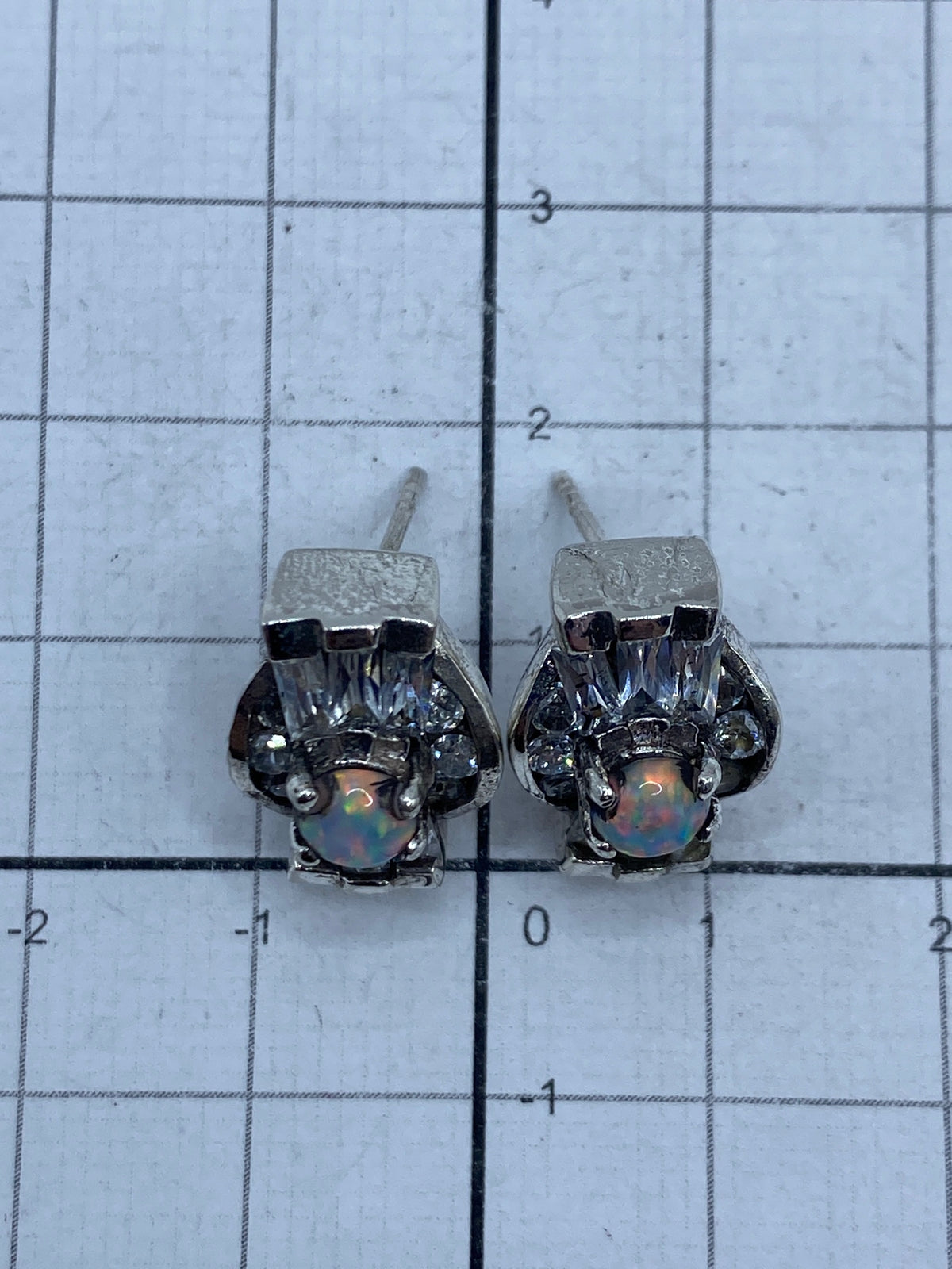 Aretes sobre escala con Quinto 925 visible, pesando 6.6 gramos el par