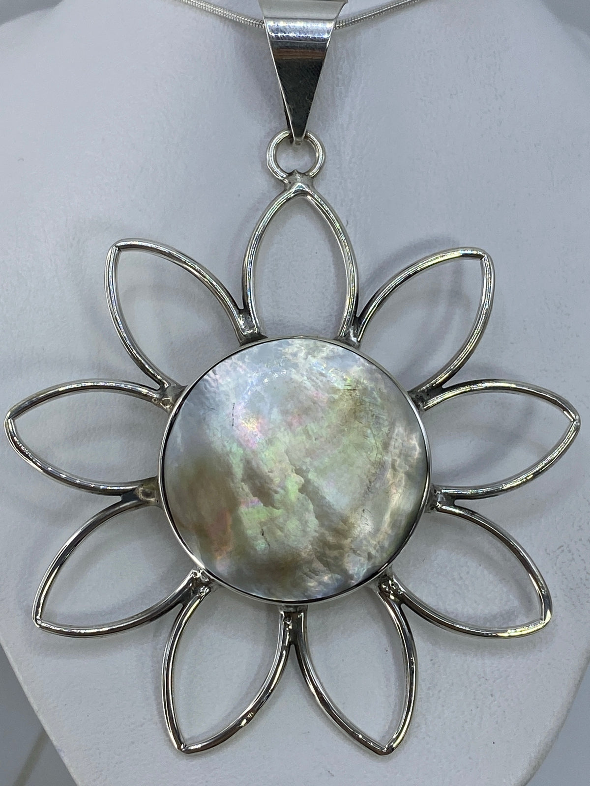 Dije flor de plata 950 con incrustacion de piedra, vista frontal sobre fondo blanco