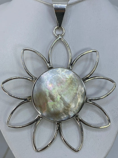 Dije flor de plata 950 con incrustacion de piedra, vista frontal sobre fondo blanco