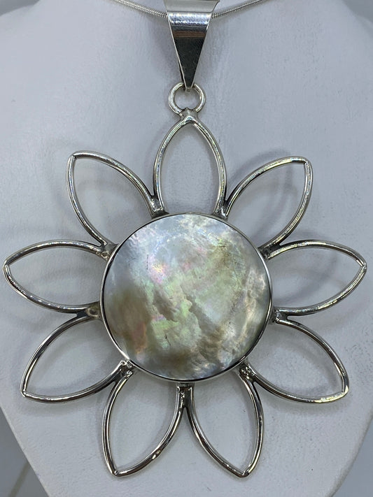 Dije flor de plata 950 con incrustacion de piedra, vista frontal sobre fondo blanco