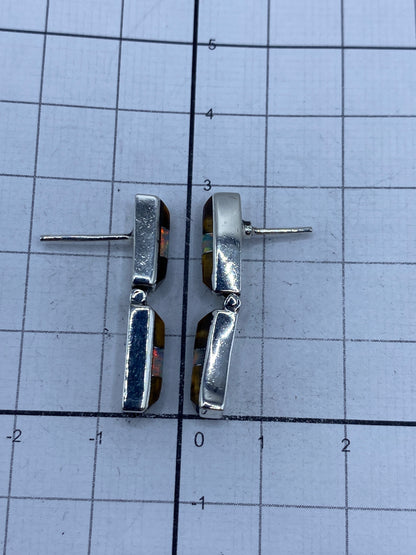 Aretes sobre fondo blanco con poste plateado visible, mostrando la pureza 950 del metal