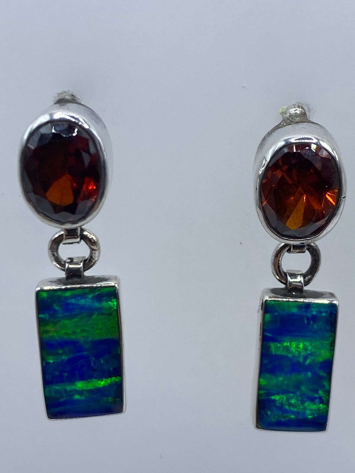 Detalle del ópalo de fuego azul en el engaste de plata, mostrando los destellos naturales