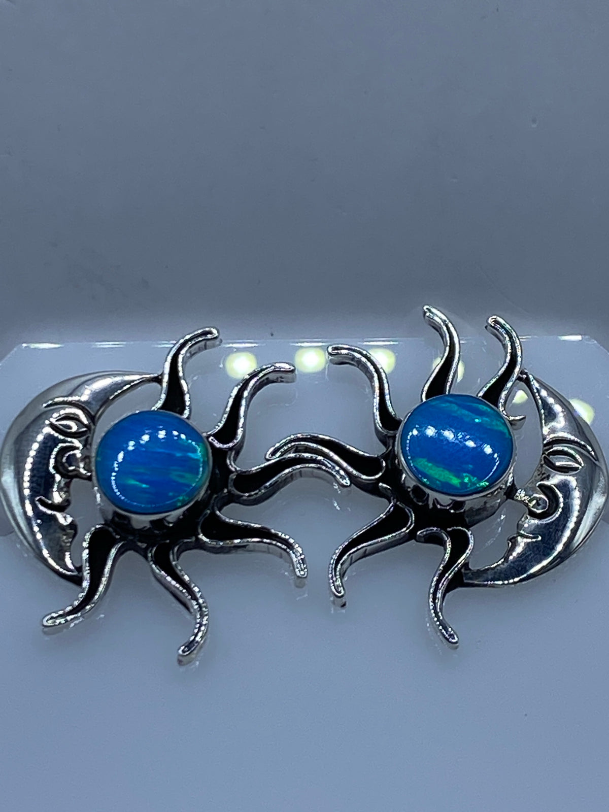 Detalle de un arete mostrando el Ópalo de Fuego azul y el engaste de plata artesanal de Taxco