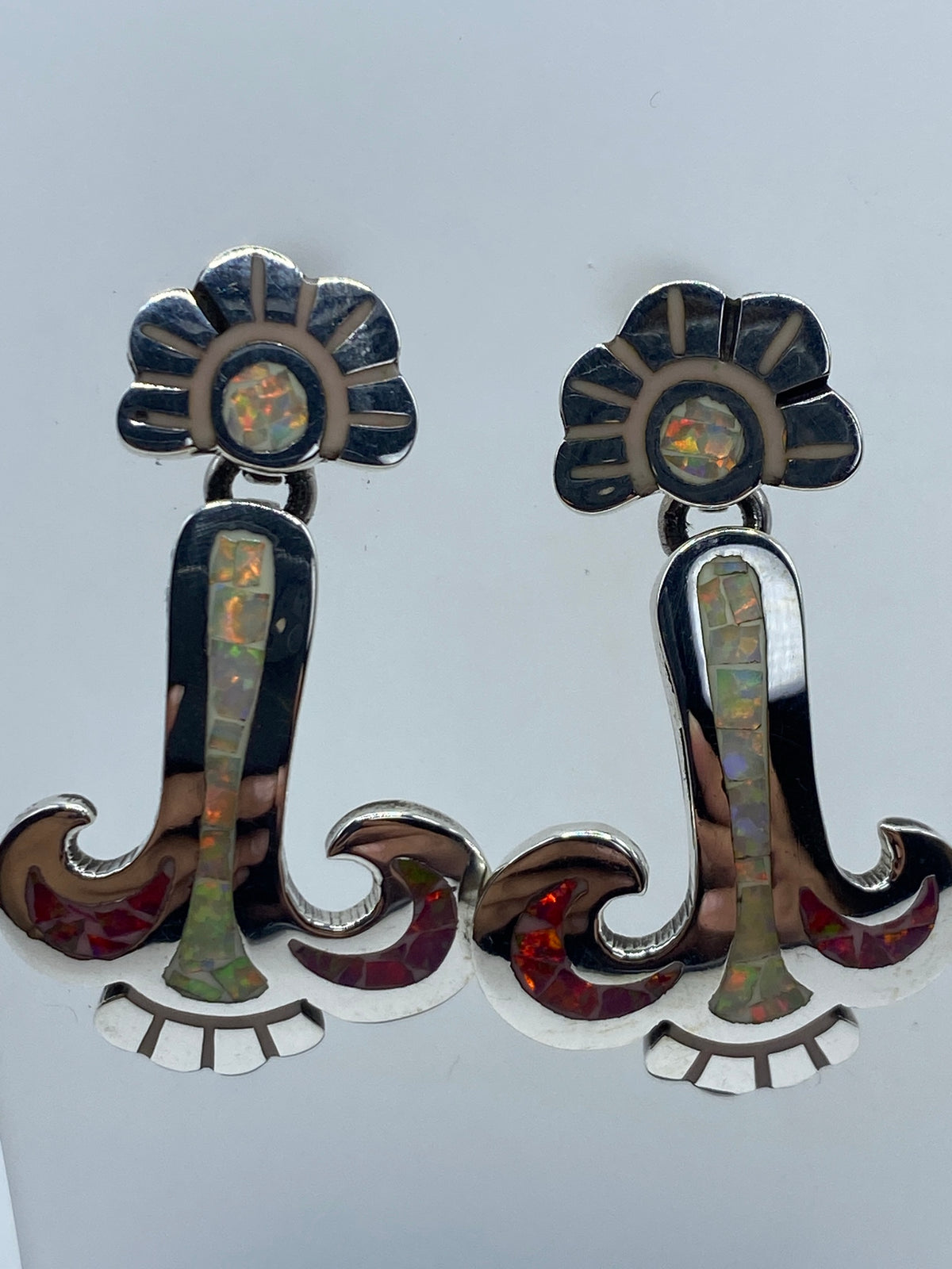 Aretes de ópalo fuego con reflejos rojos, naranjas y amarillos en posición vertical