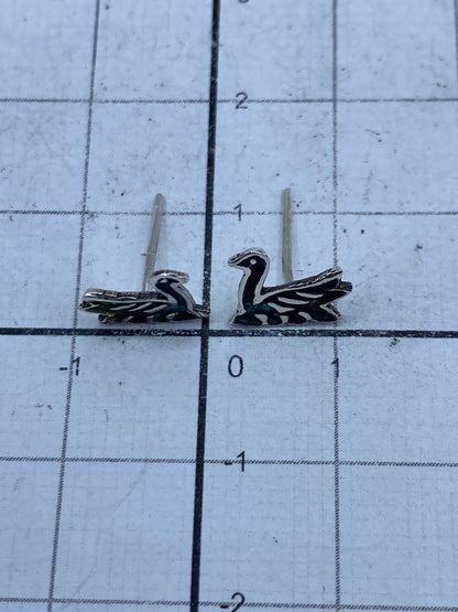 Aretes de plata pura pesados en bascula de joyero mostrando 0.9 gramos