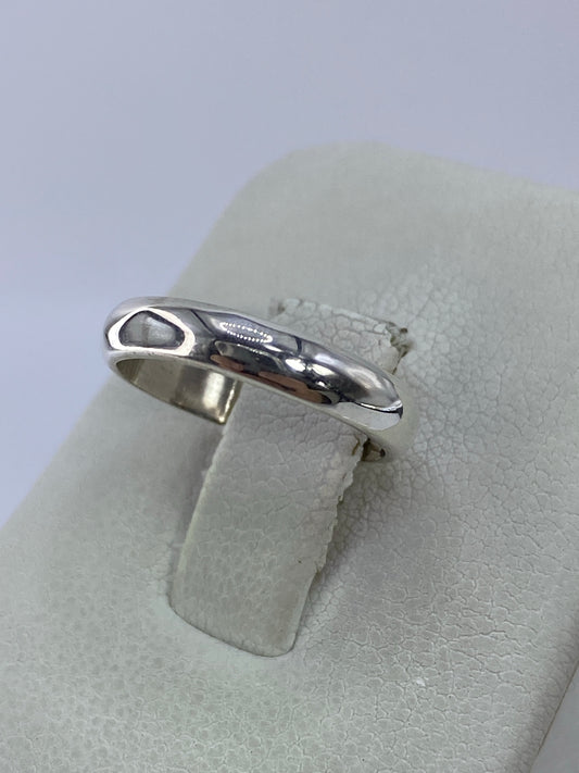 Anillo de plata pura en la mano, mostrando el brillo del pulido