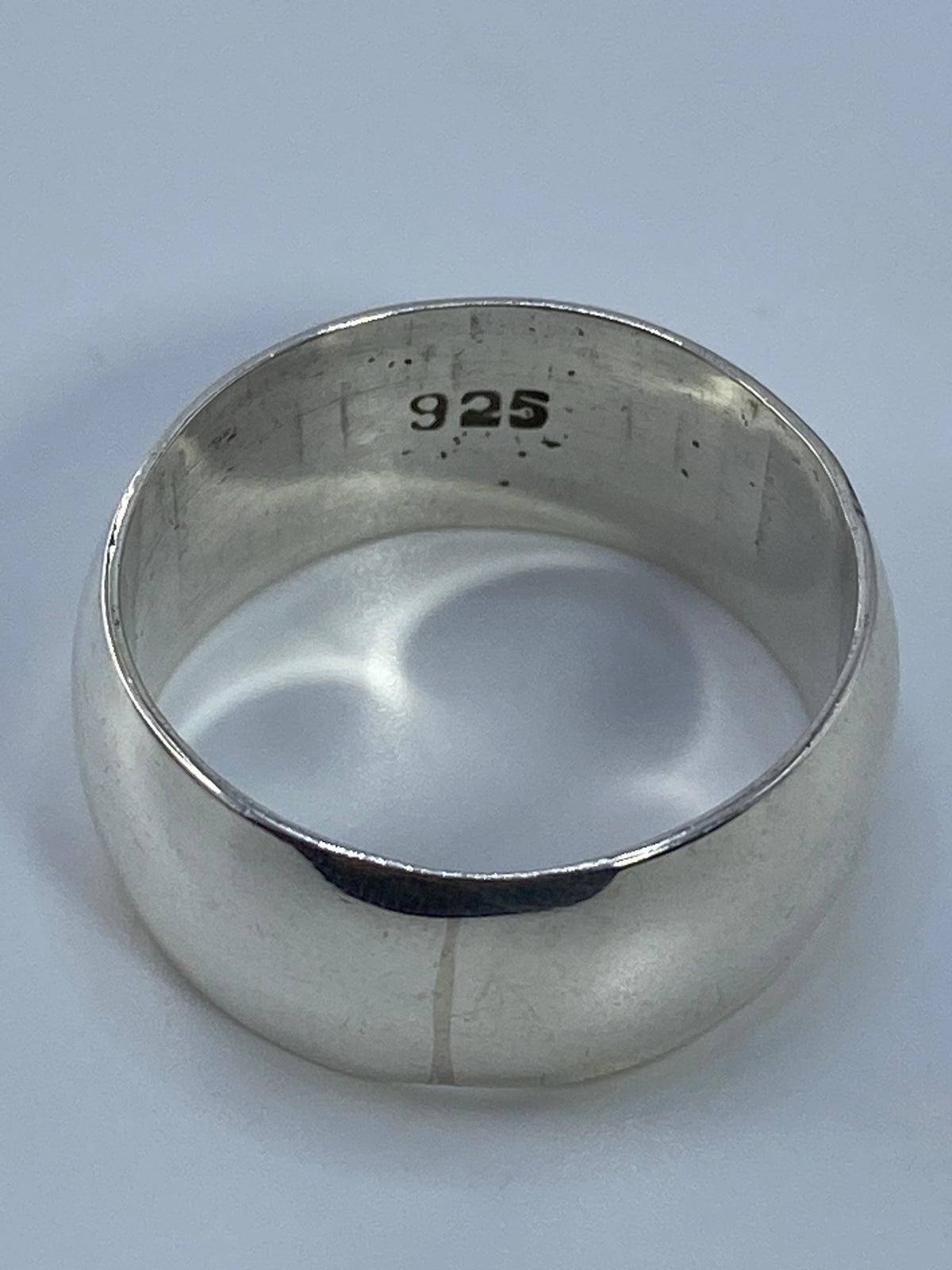 Anillo de plata en la mano, escala real del tamaño y presencia