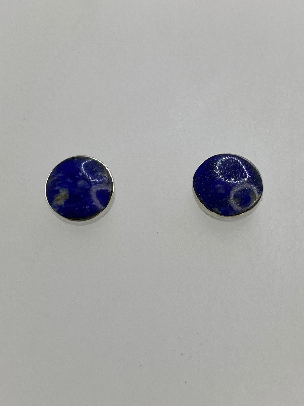 Detalle de los aretes mostrando el lapislázuli azul con vetas doradas de pirita