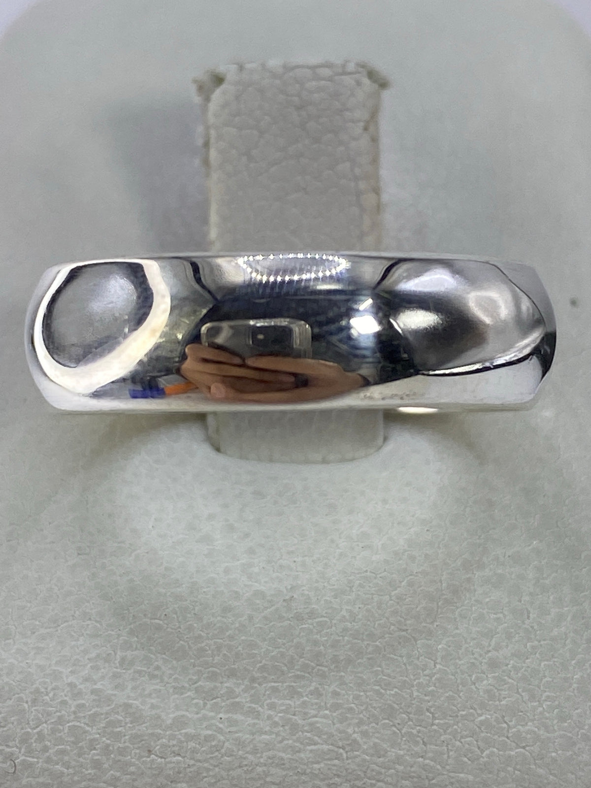 Anillo de plata 925 pulido, minimalista, en la mano sobre fondo natural