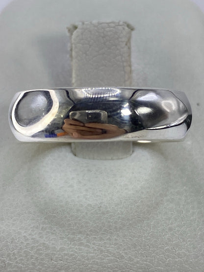 Anillo de plata 925 pulido, minimalista, en la mano sobre fondo natural