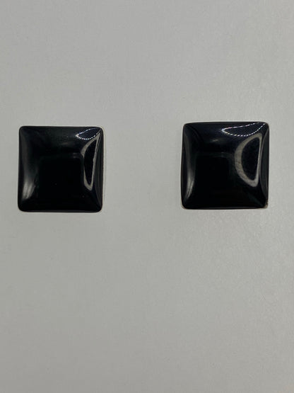 Detalle lateral de uno de los aretes mostrando el engaste a mano y el pulido de la plata
