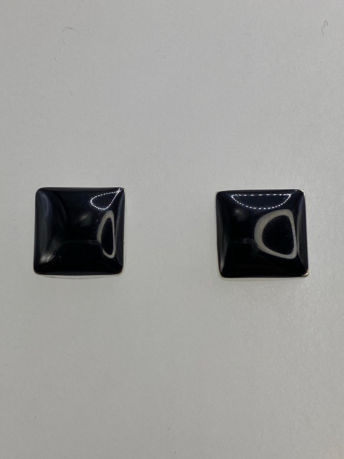 Reverso de los aretes con los posts de plata y el Quinto grabado