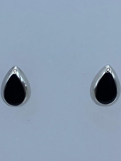Par de aretes minimalistas de plata y ónix negro, detalle del engaste a mano