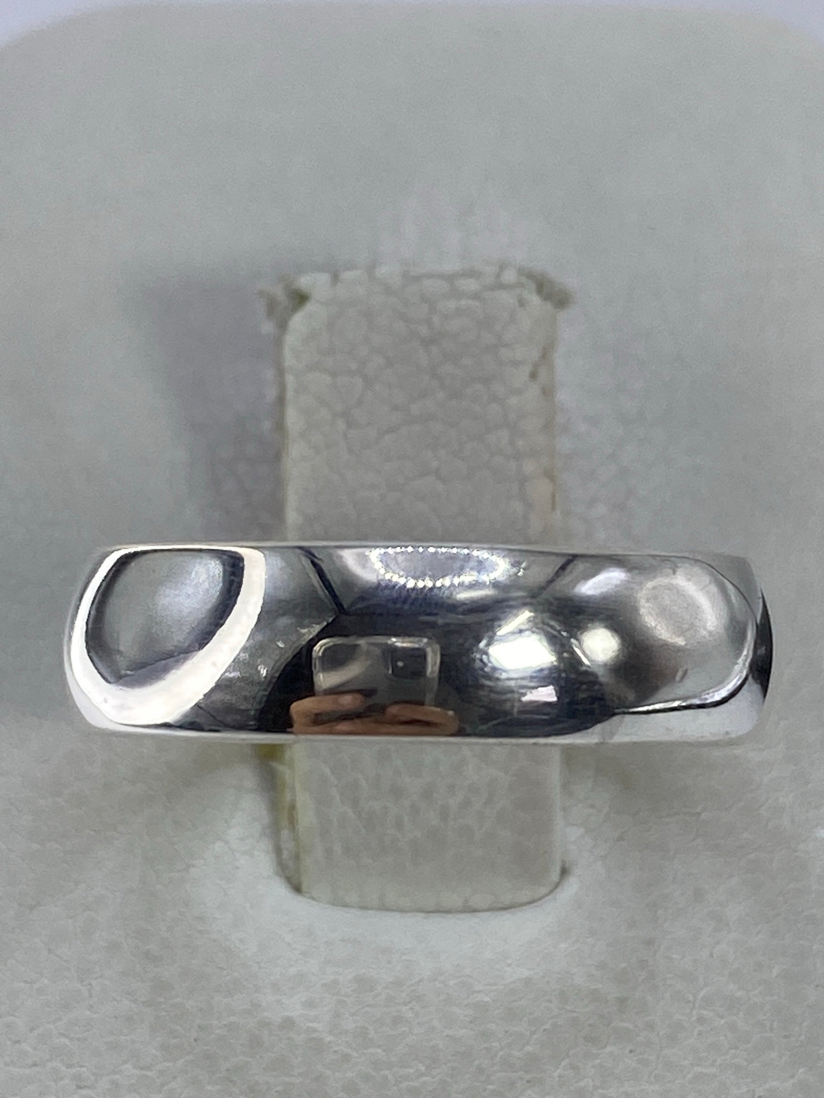 Anillo minimalista de plata 925 pulida en banda lisa sobre fondo blanco