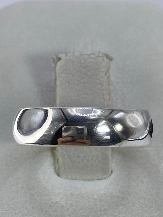 Anillo minimalista de plata 925 pulida en banda lisa sobre fondo blanco